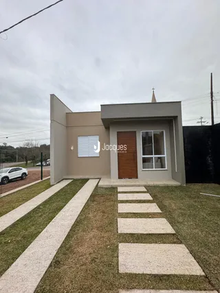 Fachada de uma residência em Lajeado, Brasil, com jardim e calçadas de concreto.