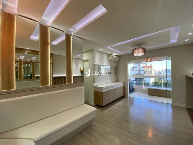 Sala de estar moderna com piso de madeira clara e vista para o exterior.