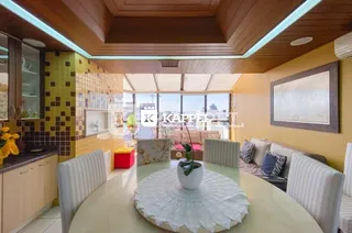 Sala de jantar com mesa e cadeiras em um ambiente bem iluminado.