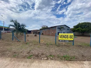 Vista externa de um terreno com edificações no fundo.