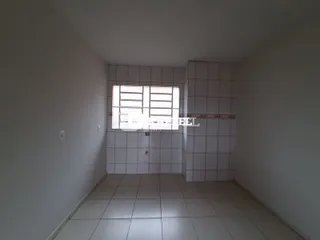 Hall de entrada com paredes de azulejo e piso claro.