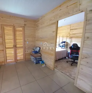 Um cômodo com paredes de madeira e piso de cerâmica, com itens de armazenamento visíveis.