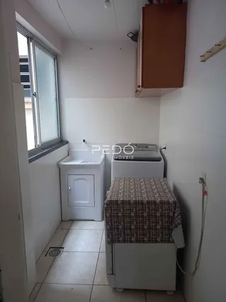 Interior de um cômodo com janela e máquina de lavar roupa.