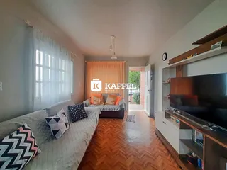 Sala de estar com sofá e piso de madeira aparente.