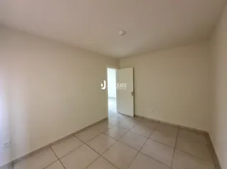 Hall de corredor com piso de cerâmica e paredes brancas.