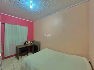 Quarto com cama e janela em ambiente com paredes coloridas.
