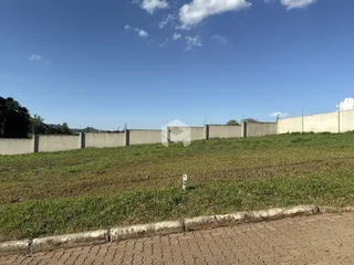 Vista externa de um muro de concreto e campo gramado.
