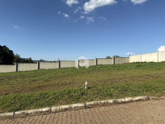 Vista externa de um muro de concreto e campo gramado.