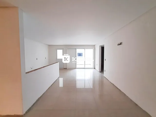 Foto de um corredor interno de uma residência com piso de cerâmica e paredes brancas.