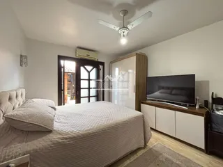 Quarto com cama, armário de madeira e piso de madeira.