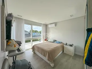 Quarto com janela de vidro e piso de madeira em Lajeado.