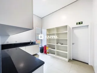 Foto de uma cozinha com armários brancos e bancada escura em um imóvel.