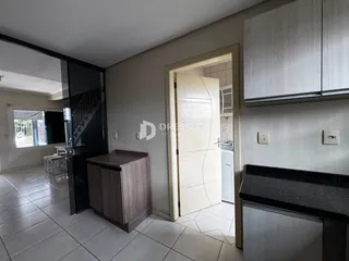 Sala de estar com piso de cerâmica e porta de vidro que dá acesso ao exterior.