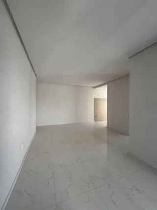 Hall de entrada com piso de mármore claro e paredes brancas.