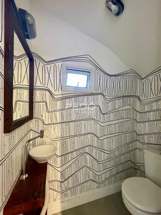 Foto de um banheiro com paredes decoradas em padrão preto e branco.
