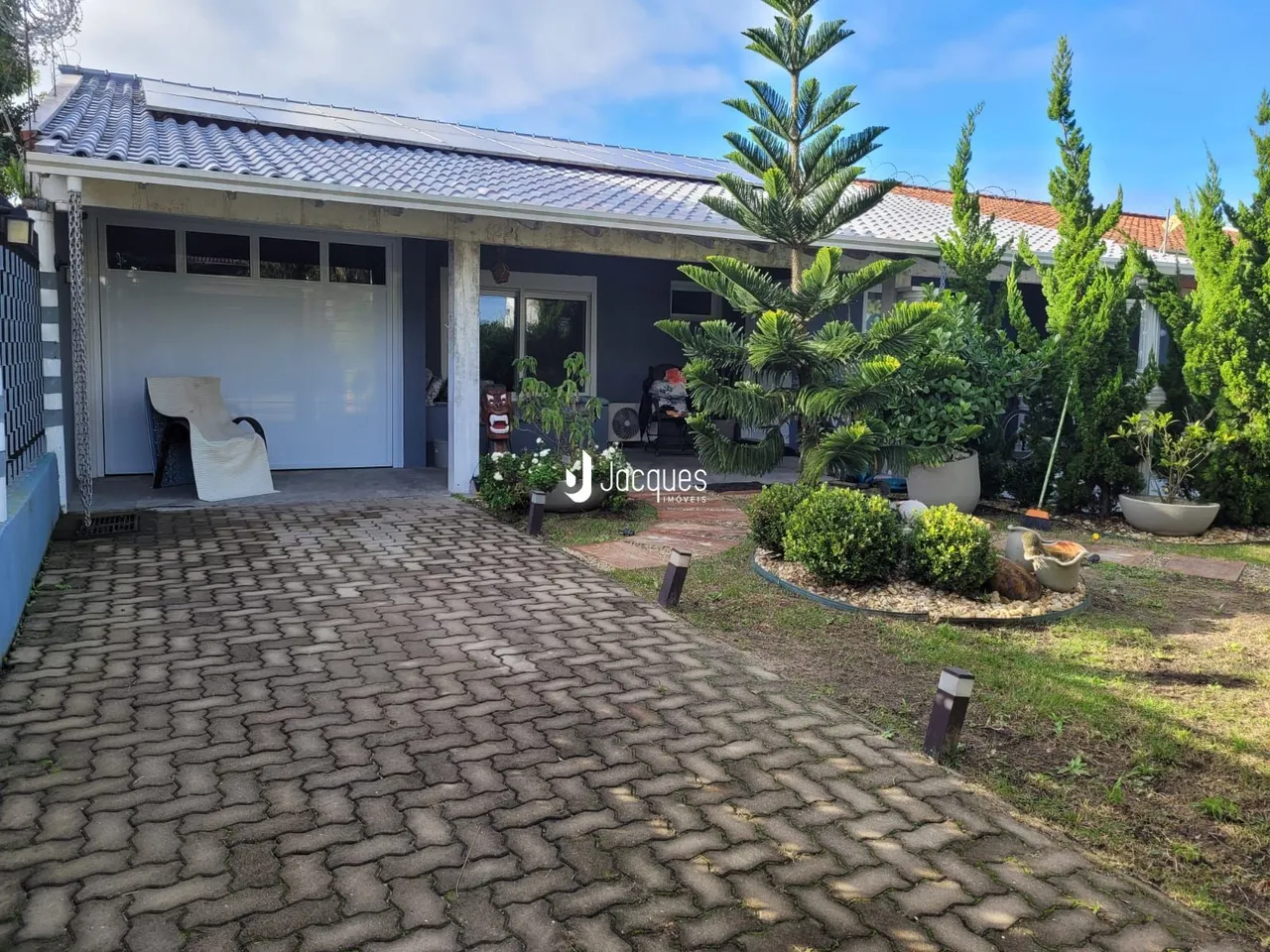 Vista da fachada de uma casa em Lajeado, Brasil, com jardim e entrada pavimentada.