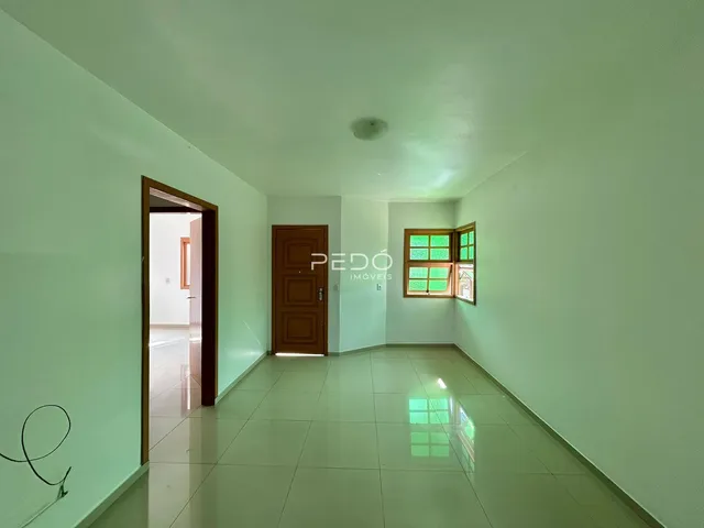 Hall de entrada com paredes verdes e piso claro em imóvel no Brasil.