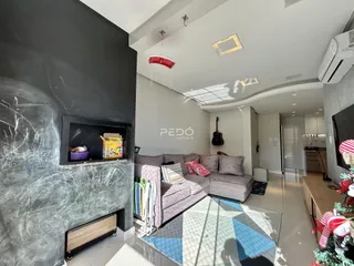 Sala de estar moderna com lareira e sofá em um imóvel no Brasil.