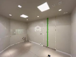 Vista interna de uma sala com paredes de gesso expostas em construção.