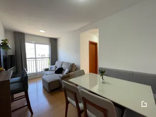 Sala de estar com sofá e mesa de jantar em um apartamento.