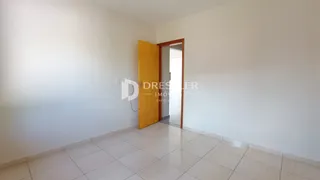 Interior de uma área com piso de cerâmica e porta de madeira.