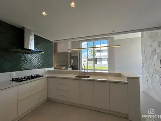 Cozinha moderna com armários brancos e bancada clara.