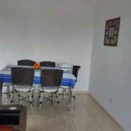 Ambiente interno com mesa e cadeiras em uma sala clara.