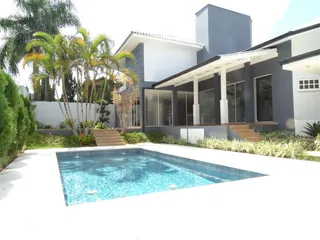 Foto da fachada de uma residência com piscina e jardim em Lajeado.