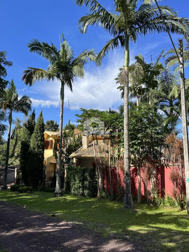 Vista da fachada de uma residência com vegetação tropical.