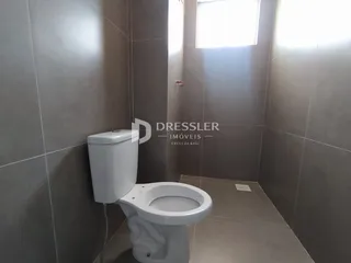 Foto de um banheiro com revestimento de cerâmica clara.