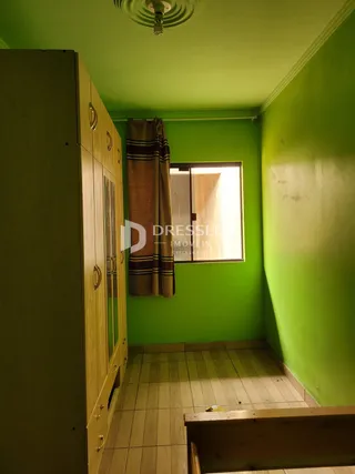 Interior de um cômodo com paredes verdes e armário de madeira.