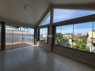 Vista ampla de uma sala com grandes janelas que se abre para o exterior.