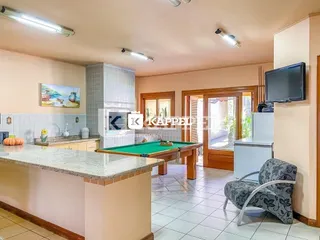 Cozinha com mesa de bilhar e bancada em ambiente interno.