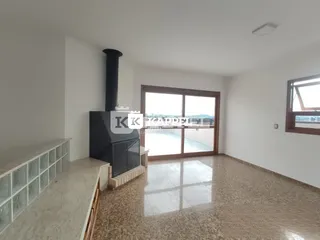 Sala de estar com lareira e vista externa.