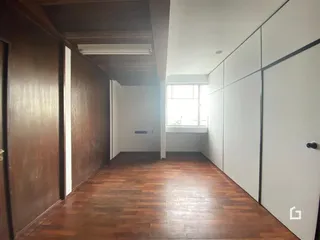 Foto do corredor interno de uma residência com piso de madeira.