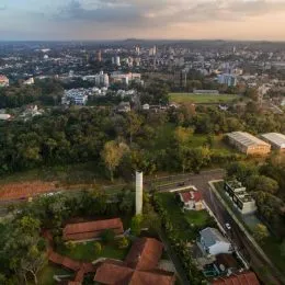 Vista aérea mostrando uma área verde com vegetação e uma estrada no horizonte.