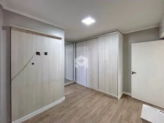 Um quarto com armários embutidos e piso de madeira clara.