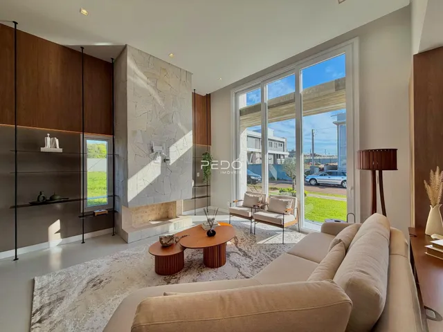 Sala de estar moderna com grandes janelas que dão vista para o exterior.