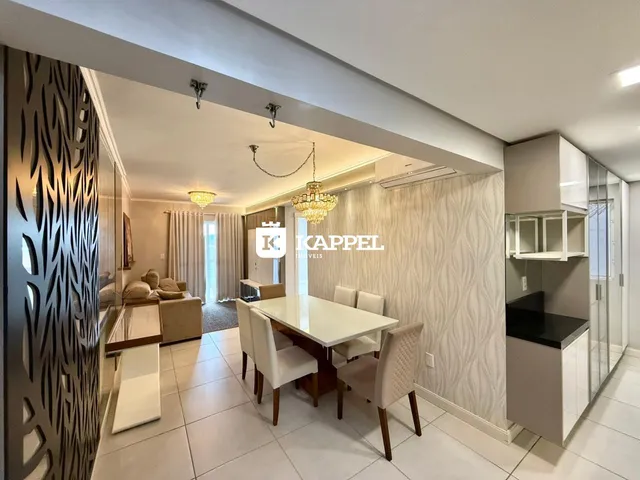 Sala de jantar com mesa de jantar e iluminação de lustre.