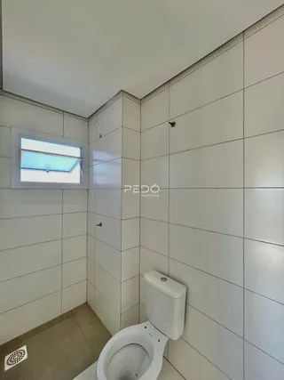 Foto de um banheiro com revestimento cerâmico branco.