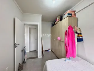Quarto com guarda-roupa de madeira e cama em um imóvel em Lajeado.
