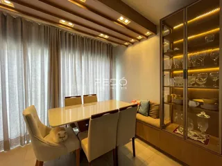 Uma sala de jantar com mesa e cadeiras em um ambiente bem iluminado.