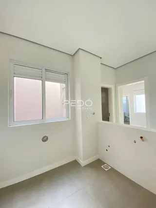 Vista interna de um cômodo com paredes brancas e piso claro.