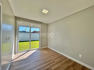 Hall com portas de vidro que dão para um gramado verde.
