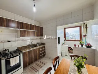 Foto interna de uma cozinha com armários e piso cerâmico.