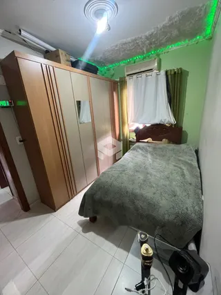 Quarto com armários em madeira e cama.