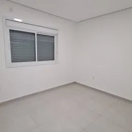 Foto de um cômodo interno com paredes brancas e uma janela.