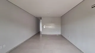 Hall de entrada com paredes brancas e piso claro.