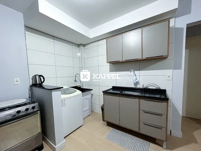 Foto de uma cozinha com armários e bancadas em um imóvel.