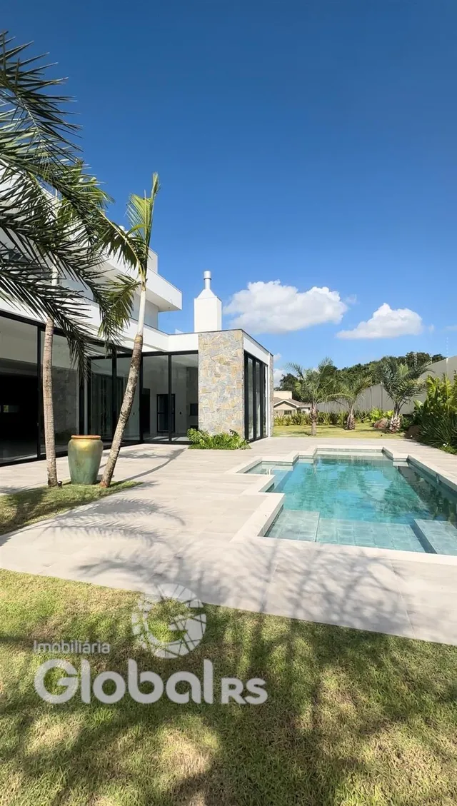Fachada de uma casa moderna com piscina e jardim em Lajeado, Brasil.